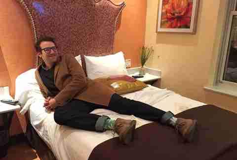 Guy sitting on bed in hotel