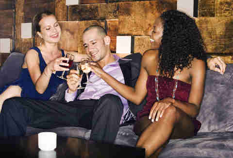 man and two woman at a bar/lounge having drinks