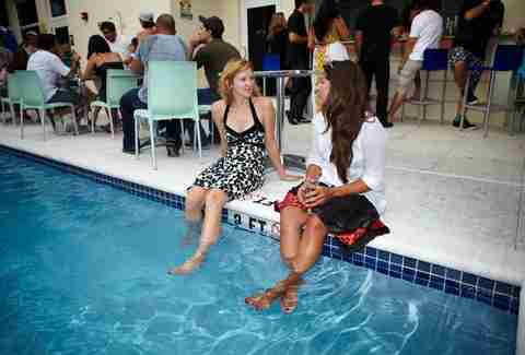 Two women day drinking at the pool in Lou's Beer Garden in Miami, Florida