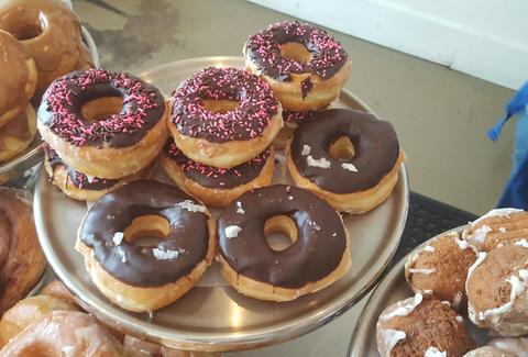 Chocolate glazed donuts on elevated cake dish