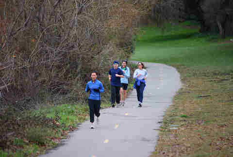 Group of adults running on outside trail