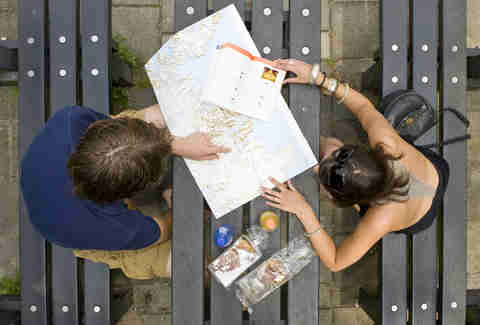 man and woman looking at a map planning a trip