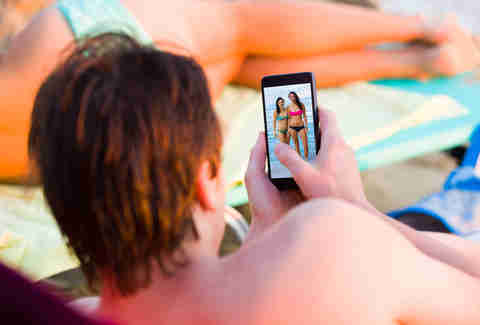 man looking at pictures of women on his phone