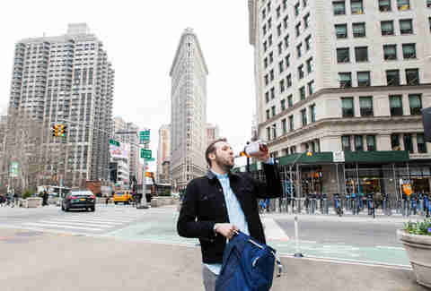 Man drinking in front of Flatiron Building