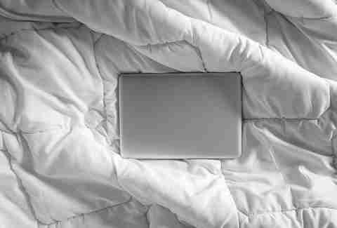 Closed laptop on bed