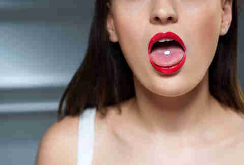 woman swallowing pill