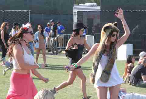 Two girls dance as another runs by at Coachella 2013