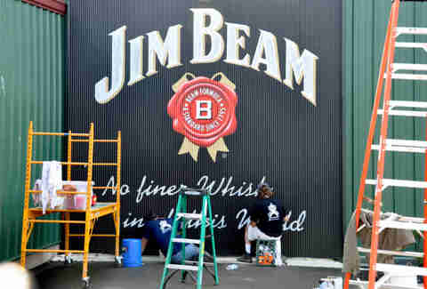Painters finishing a Jim Beam sign on the stillhouse exterior