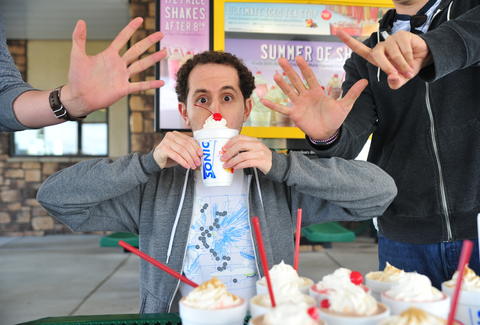 guy eats a caramel milkshake at Sonic