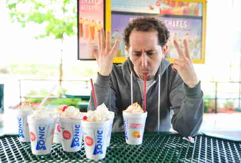 guy eats a strawberry cheesecake milkshake at Sonic