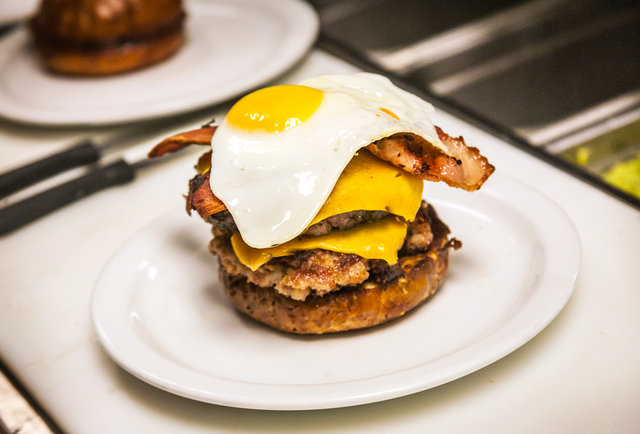 Chef tops off the 'Merica Burger with a fried egg at Slater's 50/50 in San Diego.-This 'Merica Burger is basically 100% made of bacon