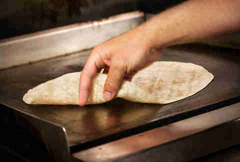 Warming up the tortilla for the Supreme Nacho Burger at Slater's 50/50 in Liberty Station San Diego.