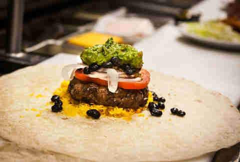 Next comes a scoop of guacamole on the Supreme Nacho Burger at Slater's 50/50 in Liberty Station San Diego.