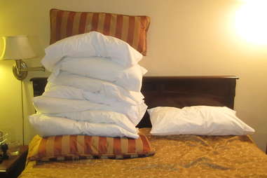 mountain of pillows on bed