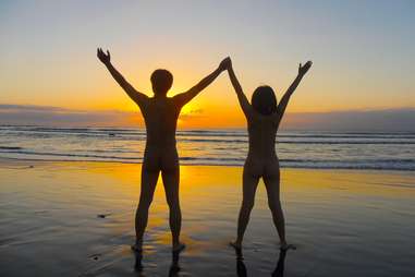 Couple nude on beach at sunset