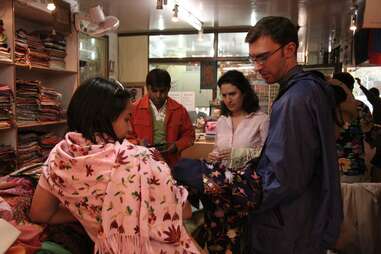 Man buying local clothing with wife