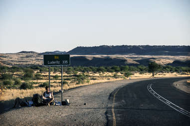 hitchhiking by a sign