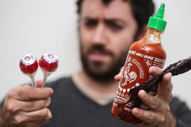 holding sriracha and lollypop