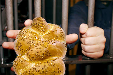 Prisoner locked up reaching for challah bread