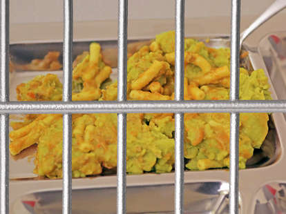 Prison food on cafeteria tray behind bars