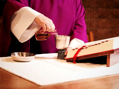 Priest pouring communion wine
