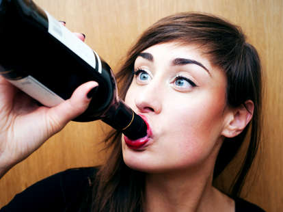 Woman drinking bottle of wine