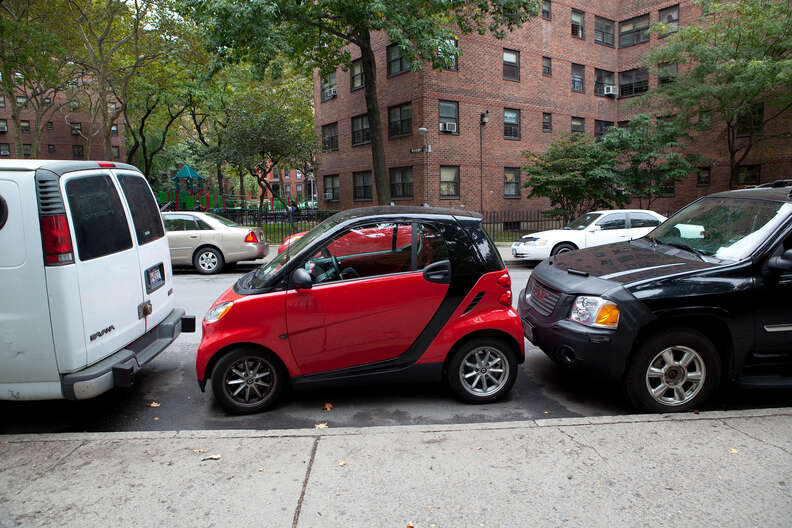 smart car parked in between two others in new york city