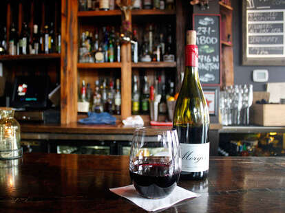 glass of red wine and bottle in cozy interior of Balzac in Milwaukee
