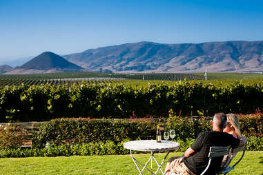 Couple sitting in front of vineyard