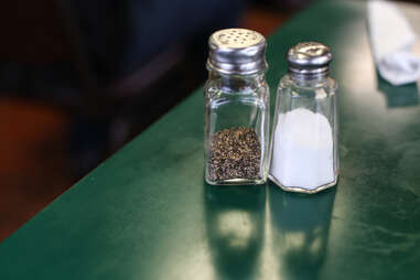 Things You Should Never Do in a Restaurant salt and pepper on a table close up