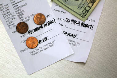 Things You Should Never Do at a Restaurant close up of bills money and change at a restaurant