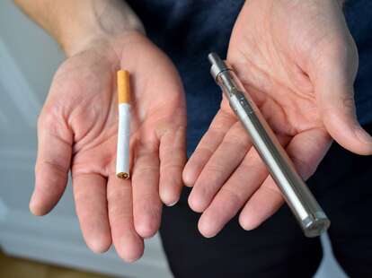 man deciding between cigarette and vaping