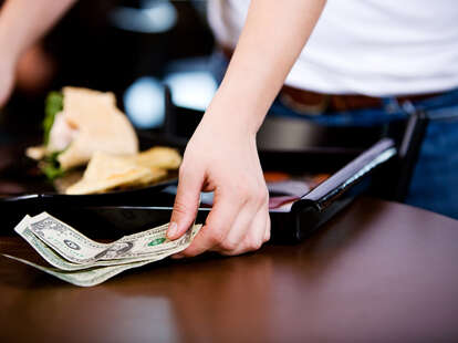 Man leaving tip on table