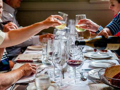 Diners drinking wine and reading menus at Charlotte wine bar