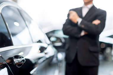 Car dealer standing on a showroom floor