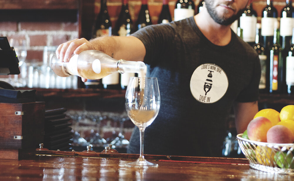 Bartender pouring glass of white wine