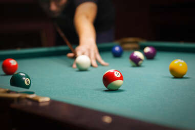 Person playing shooting cue ball in a game of pool