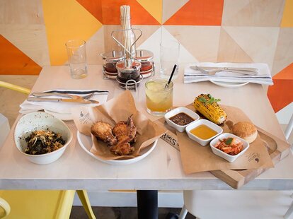 umami fried chicken, braised kale, biscuits, grilled corn and whiskey at The Peached Tortilla