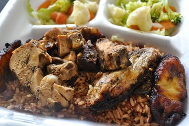 caribbean jerk chicken and vegetables in a takeout container