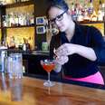 D.C. bartender fixing garnish on orange cocktail
