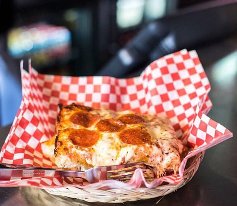 Square slice of Golden Boy pizza in basket
