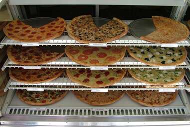 Different types of pizzas laid out at Pizza Shop