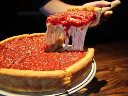 Man cutting slice of Patxis deep dish pizza