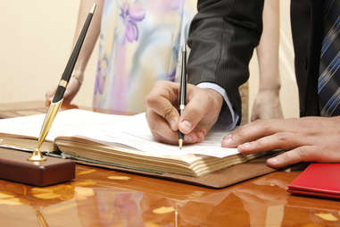 man and woman couple signing a wedding certificate
