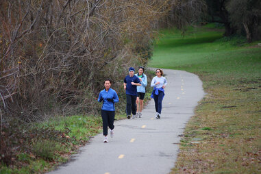Group of adults running on outside trail