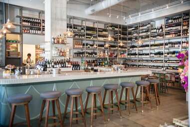 stools lined up at the bar at esters wine shop