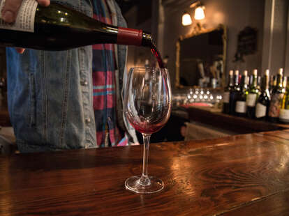 bartender pouring glass of red wine, colorado wine company