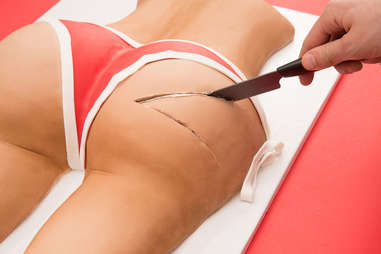 Erotic cake in shape of a butt with knife going in