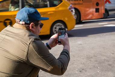 man using snapchat on iphone in the street