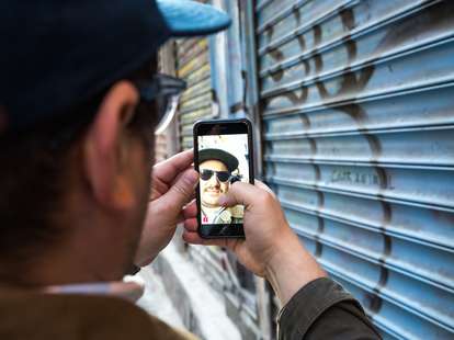 Man snapchatting by graffiti